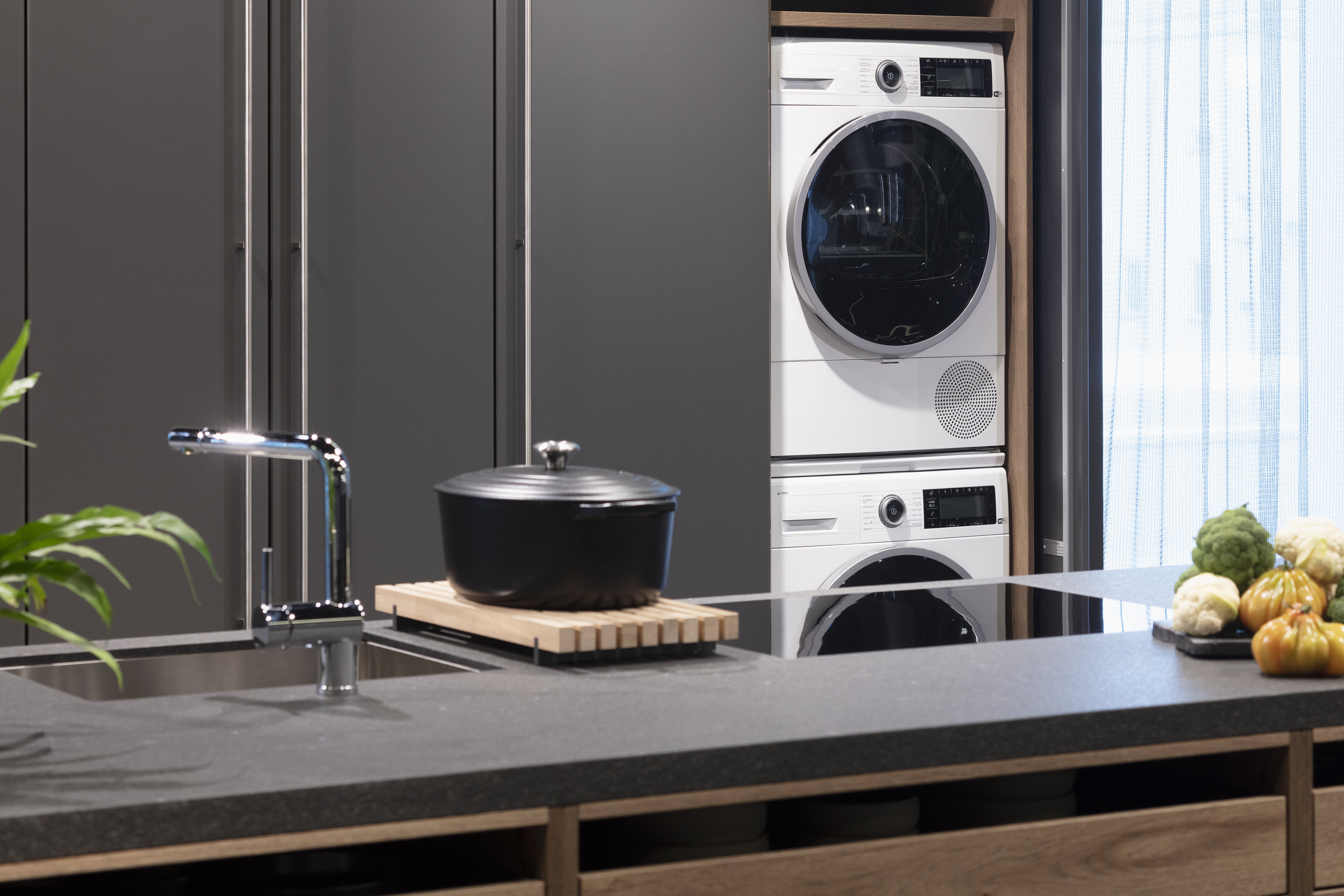 Waschmaschine und Trockner in einer LEICHT Küche hinter Pocketdoors