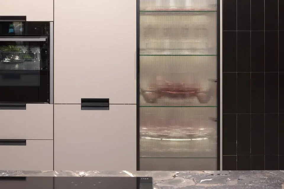 Geriffelte Glasscheiben in Vitrinenschrank in einer ansonsten altrosa gehaltenen Ballerina-Küche